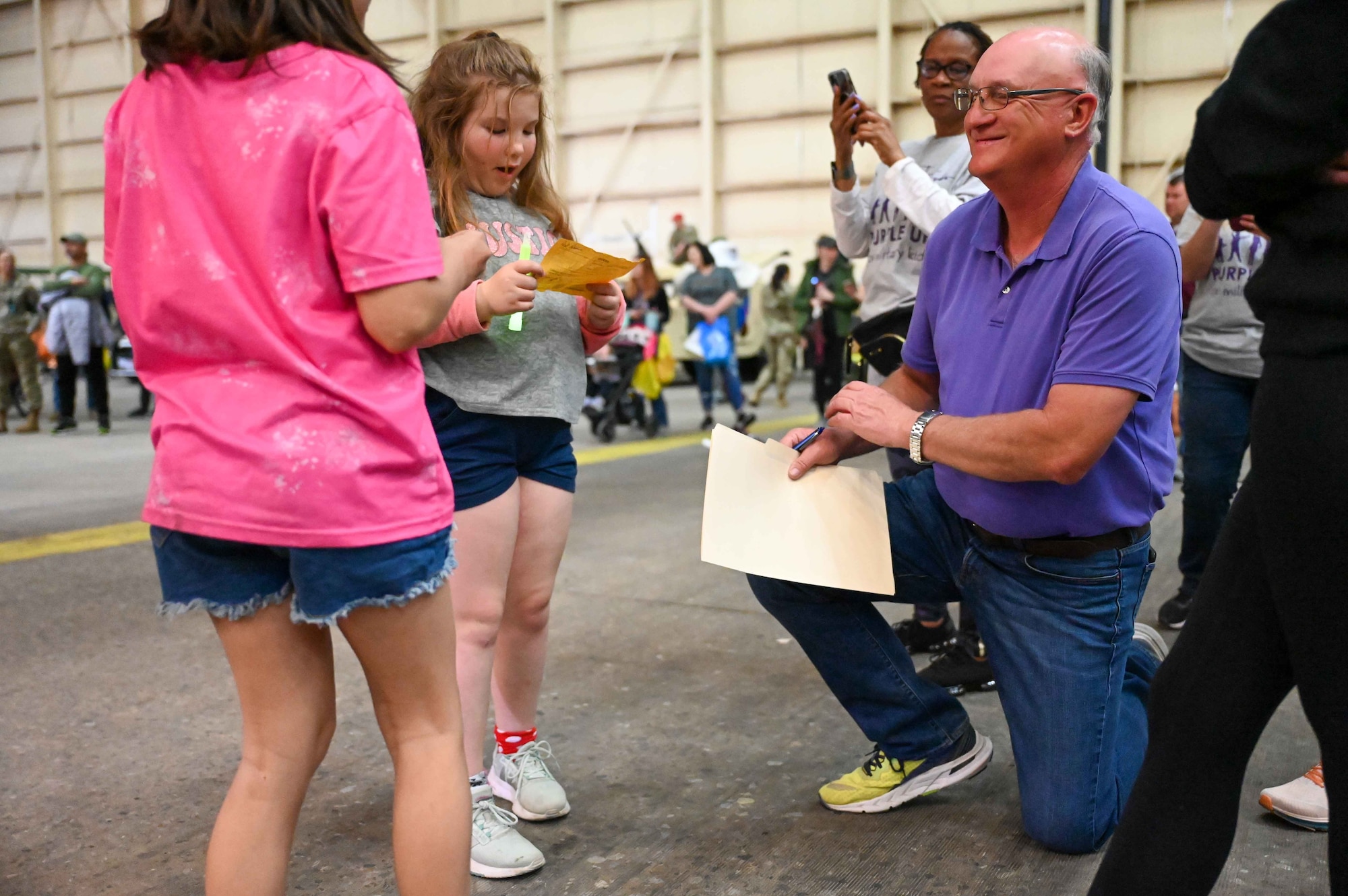 Robert Garrison, city of Altus mayor, autographs a paper for a military child during the “Kid’s Deployment Line” at Altus Air Force Base, Oklahoma, April 1, 2023. Garrison made a speech proclaiming April as “Month of the Military Child” throughout the city of Altus. (U.S. Air Force photo by Airman 1st Class Kari Degraffenreed)