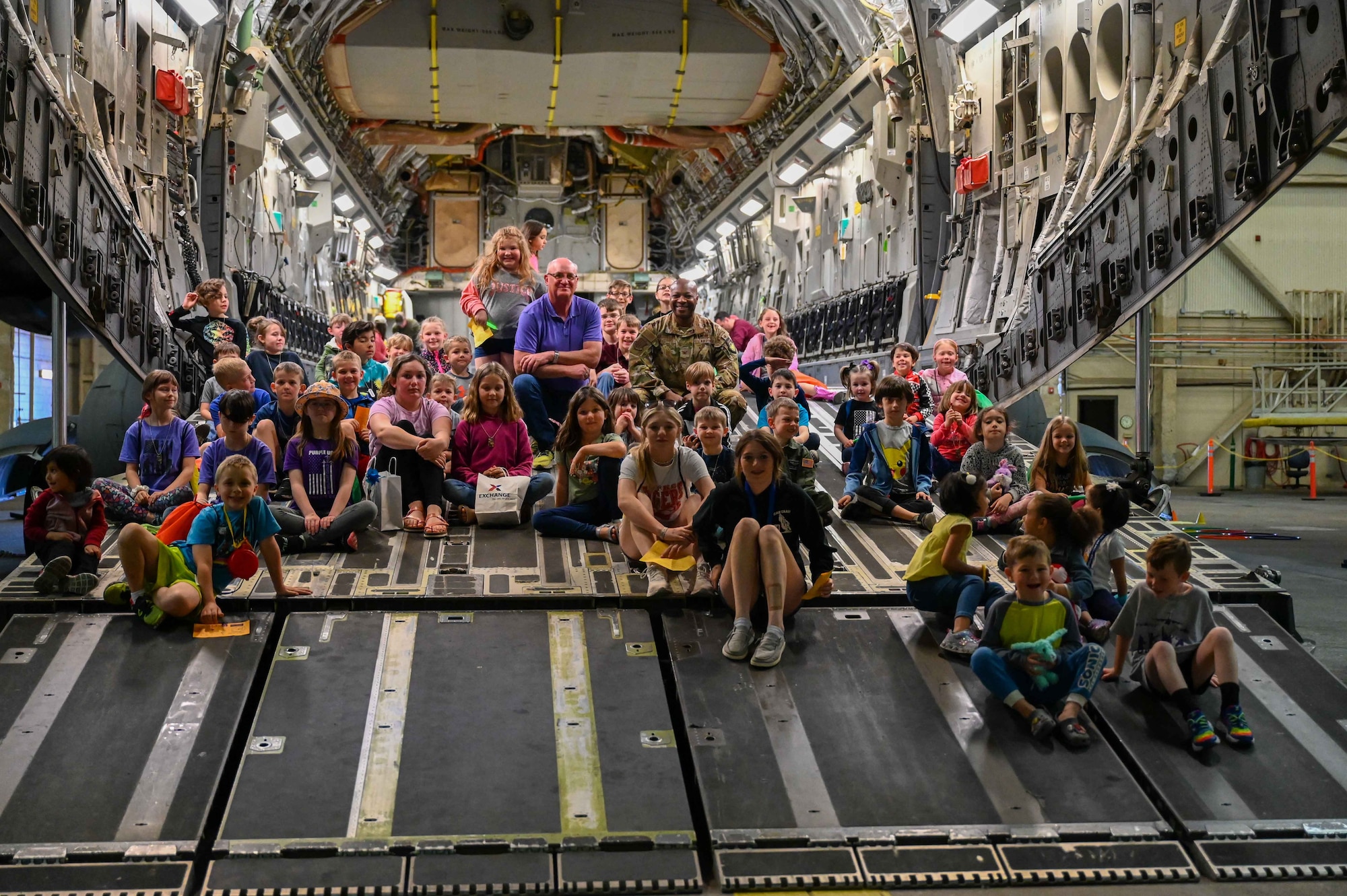 Robert Garrison (center left), city of Altus mayor, poses with U.S. Air Force Col. Patrick Brady-Lee (center right), 97th Air Mobility Wing vice commander, and children of servicemembers during the “Kid’s Deployment Line” at Altus Air Force Base (AFB), Oklahoma, April 1,2023. Airmen from the 97th Force Support Squadron’s Military and Family Readiness Center designed the “Kid’s Deployment Line” to be a fun way to honor the challenges military children face because of their parents’ service to their country. (U.S. Air Force photo by Airman 1st Class Kari Degraffenreed)