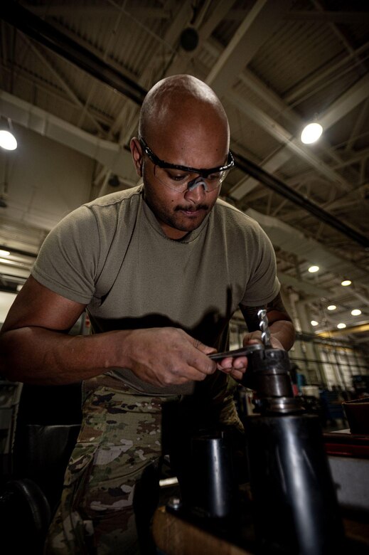 U.S. Air Force Staff Sgt. Bryce Harris, 305th Maintenance Squadron aircraft metals technology craftsman, adjusts a drill bit to be installed into a VF-4 computer numeric controlled machine on Joint Base McGuire-Dix-Lakehurst, N.J., Mar. 23, 2023.