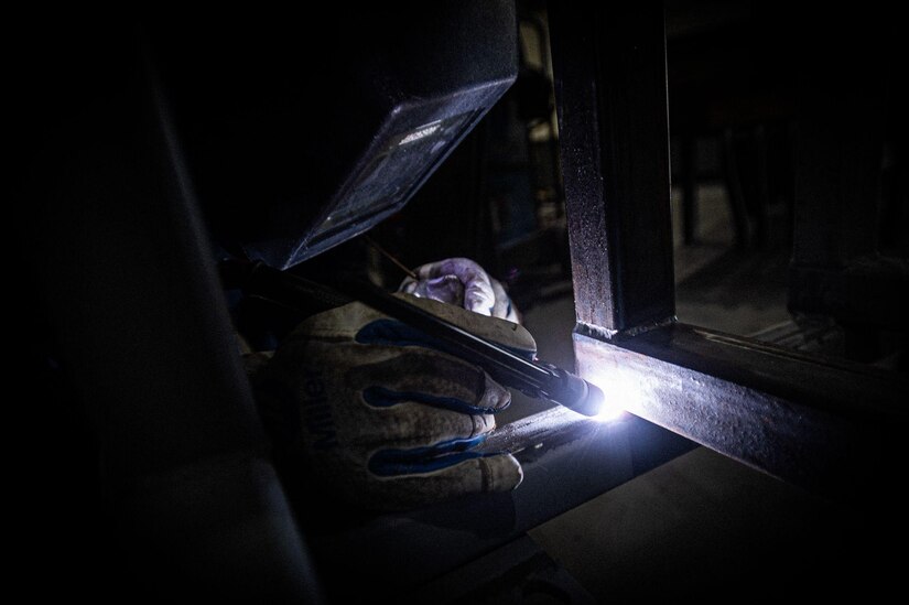 U.S. Air Force Senior Airman Jalen Castillo welds together a piece of metal to a stand