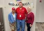 Three people stand together each wearing something RED.