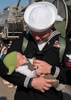 Fire Controlman (Aegis) 2nd Class Robert Heinke, assigned to the guided-missile cruiser USS Vicksburg (CG 69) and deployed with guided-missile destroyer USS Nitze (DDG 94), meets his daughter for the first time after Nitze returned to Naval Station Norfolk following a scheduled deployment April 5, 2023.