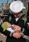 Fire Controlman (Aegis) 2nd Class Robert Heinke, assigned to the guided-missile cruiser USS Vicksburg (CG 69) and deployed with guided-missile destroyer USS Nitze (DDG 94), meets his daughter for the first time after Nitze returned to Naval Station Norfolk following a scheduled deployment April 5, 2023.