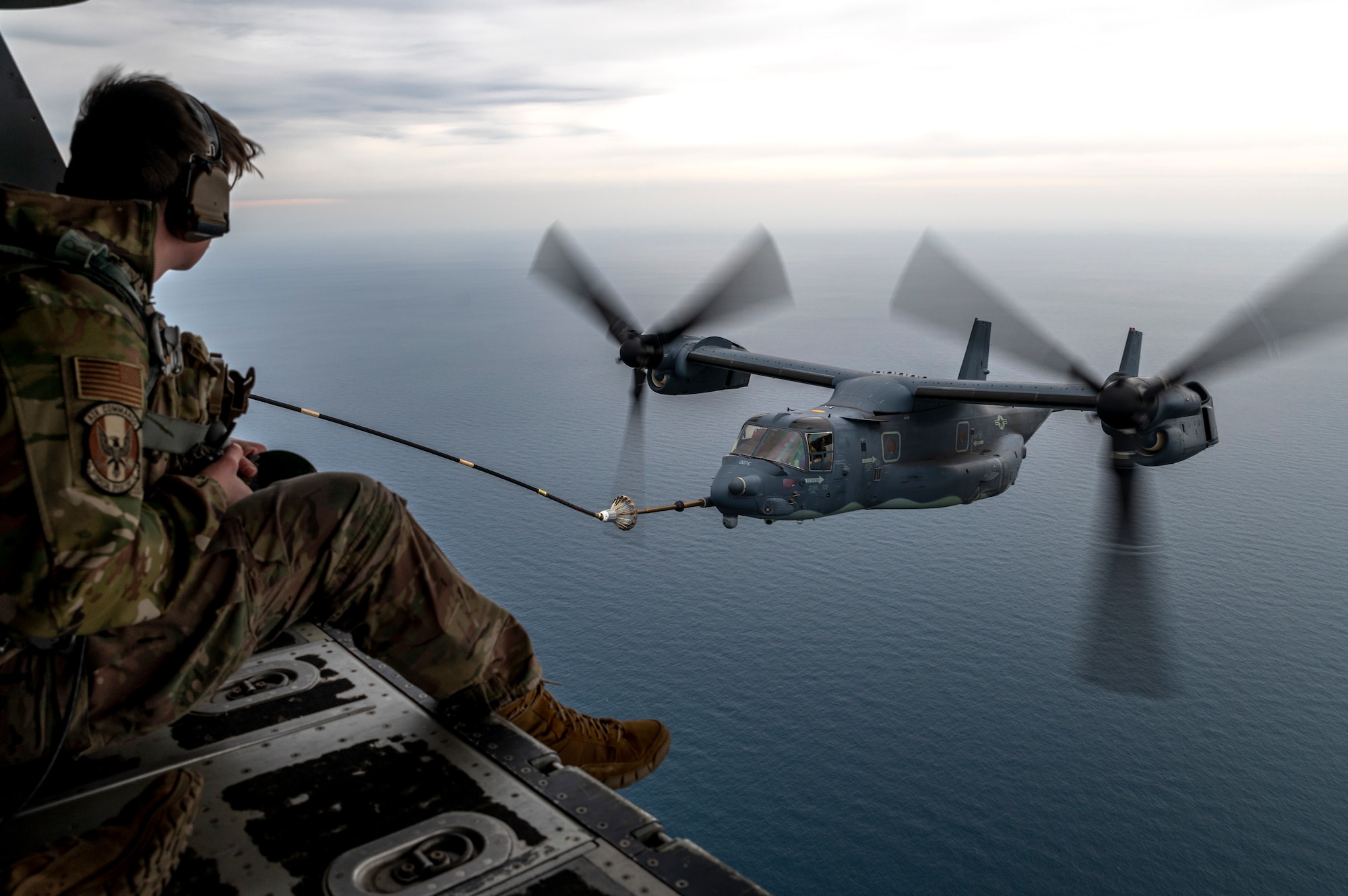 U.S. Airman assigned to the 1st Special Operations Squadron oversees the aerial refueling of a CV-22 Osprey from an MC-130J Commando II during a training mission as part of Freedom Shield 23 over the Sea of Japan, Mar. 17th, 2023.