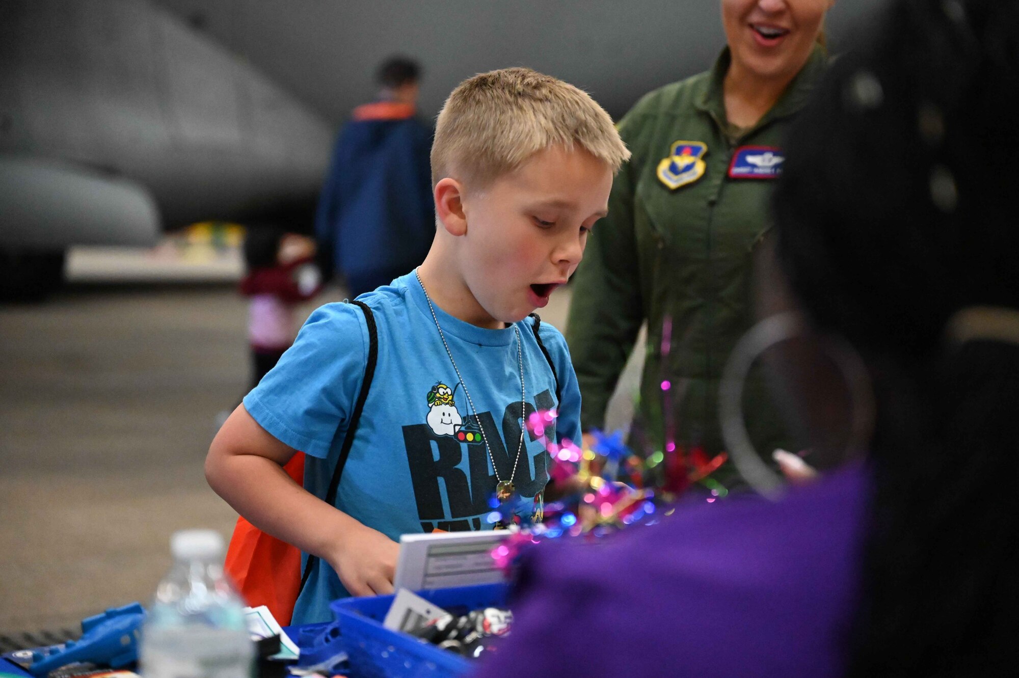 David Inmon, son of U.S. Air Force Chief Master Sgt. Andrea Inmon, 54th Air Refueling Squadron senior enlisted leader, marvels at the Military and Family Readiness Center’s table of goodies during the “Kid’s Deployment Line” at Altus Air Force Base, Oklahoma, April 1, 2023. At the start of the line, children were given “orders,” dog tags with their own last name, a canteen, and chocolate covered coins from the 97th Comptroller Squadron. (U.S. Air Force photo by Airman 1st Class Kari Degraffenreed)