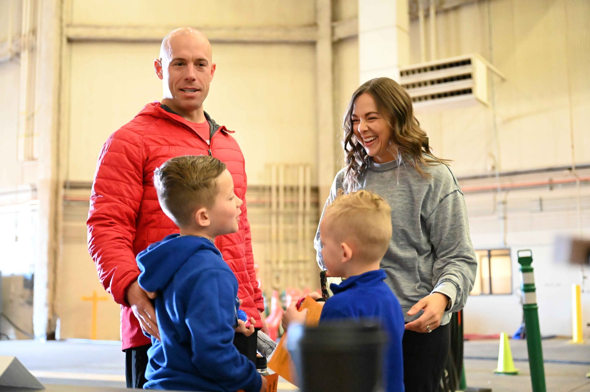A military family laughs together during the “Kid’s Deployment Line” at Altus Air Force Base, Oklahoma, April 1, 2023. The event gave children an opportunity to see what their parents go through during a real deployment line. (U.S. Air Force photo by Airman 1st Class Kari Degraffenreed)