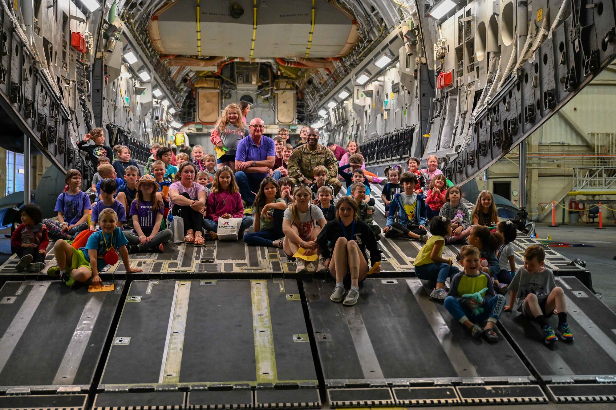 Robert Garrison (center left), city of Altus mayor, poses with U.S. Air Force Col. Patrick Brady-Lee (center right), 97th Air Mobility Wing vice commander, and children of servicemembers during the “Kid’s Deployment Line” at Altus Air Force Base (AFB), Oklahoma, April 1,2023. Airmen from the 97th Force Support Squadron’s Military and Family Readiness Center designed the “Kid’s Deployment Line” to be a fun way to honor the challenges military children face because of their parents’ service to their country. (U.S. Air Force photo by Airman 1st Class Kari Degraffenreed)