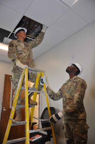 men evaluate an electrical circuit box