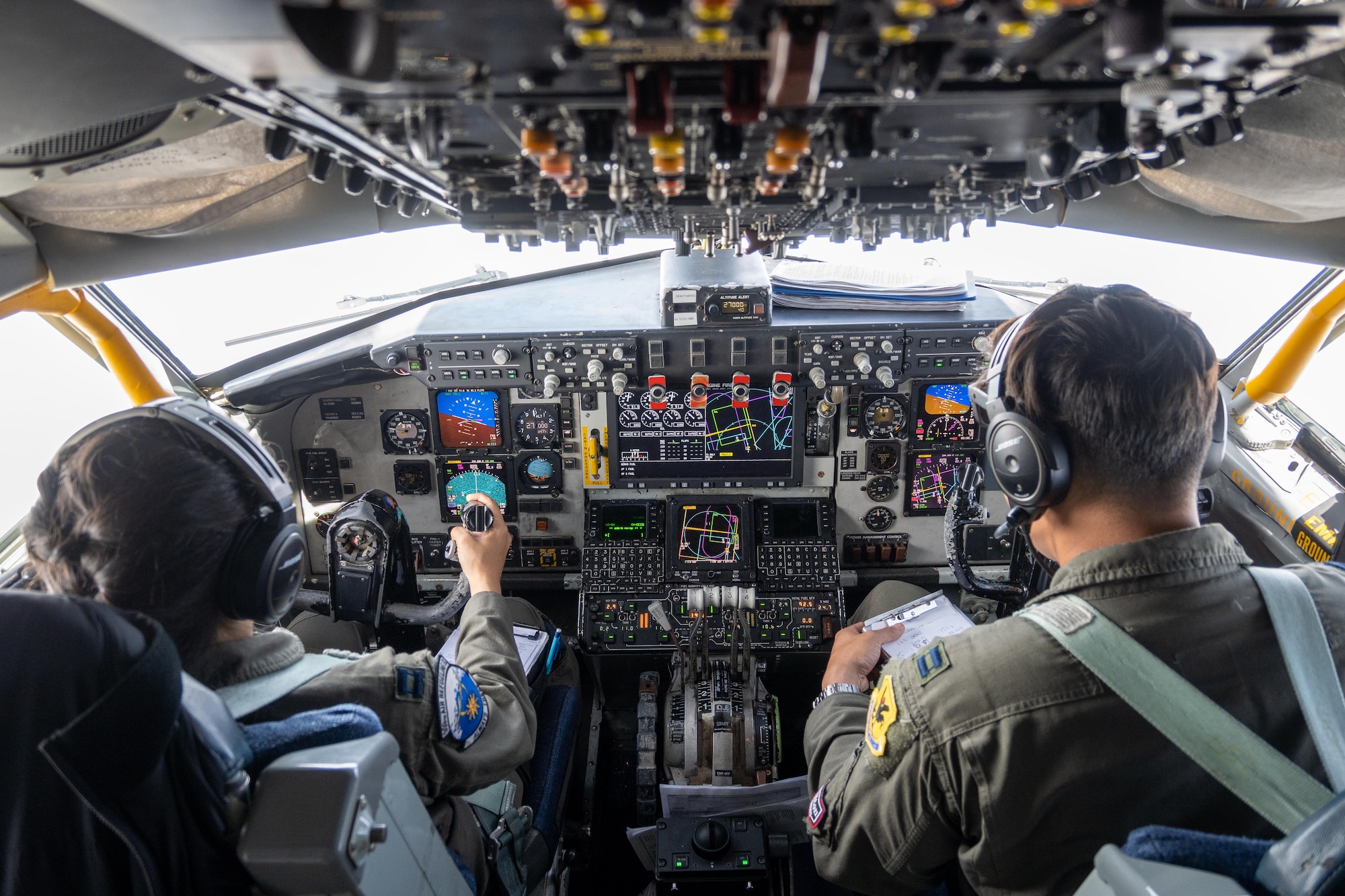 Pilots sit in the cock pit while flying a KC-135 Stratotanker