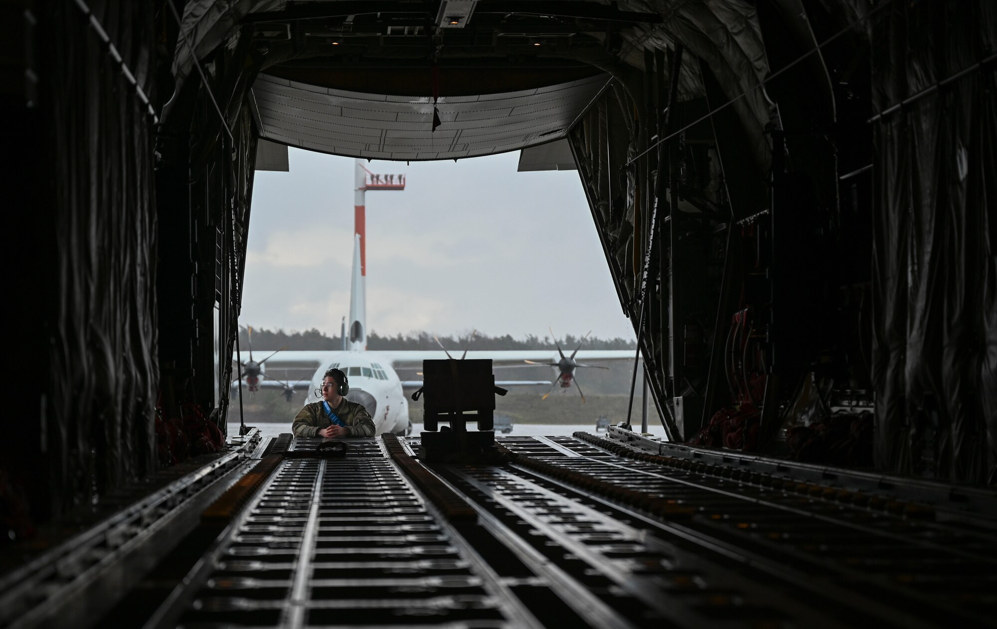 U.S. Air Force Senior Airman Donovan Elledge, 86th Aircraft Maintenance Squadron C-130J Super Hercules hydraulics journeyman, rests on the ramp of a  C-130J aircraft at Ramstein Air Base, Germany, March 31, 2023.
