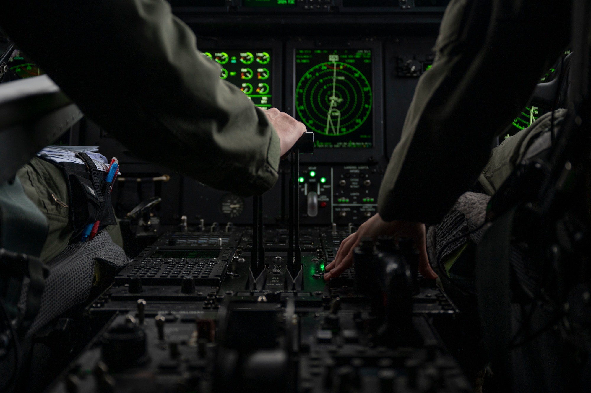 U.S. Air Force Maj. Sandra Salzman, 37th Airlift Squadron C-130J Super Hercules pilot-physician, and Capt. Megan Kraynak, 37th Airlift Squadron C-130J pilot, adjust flight controls while flying over Germany, March 31, 2023.