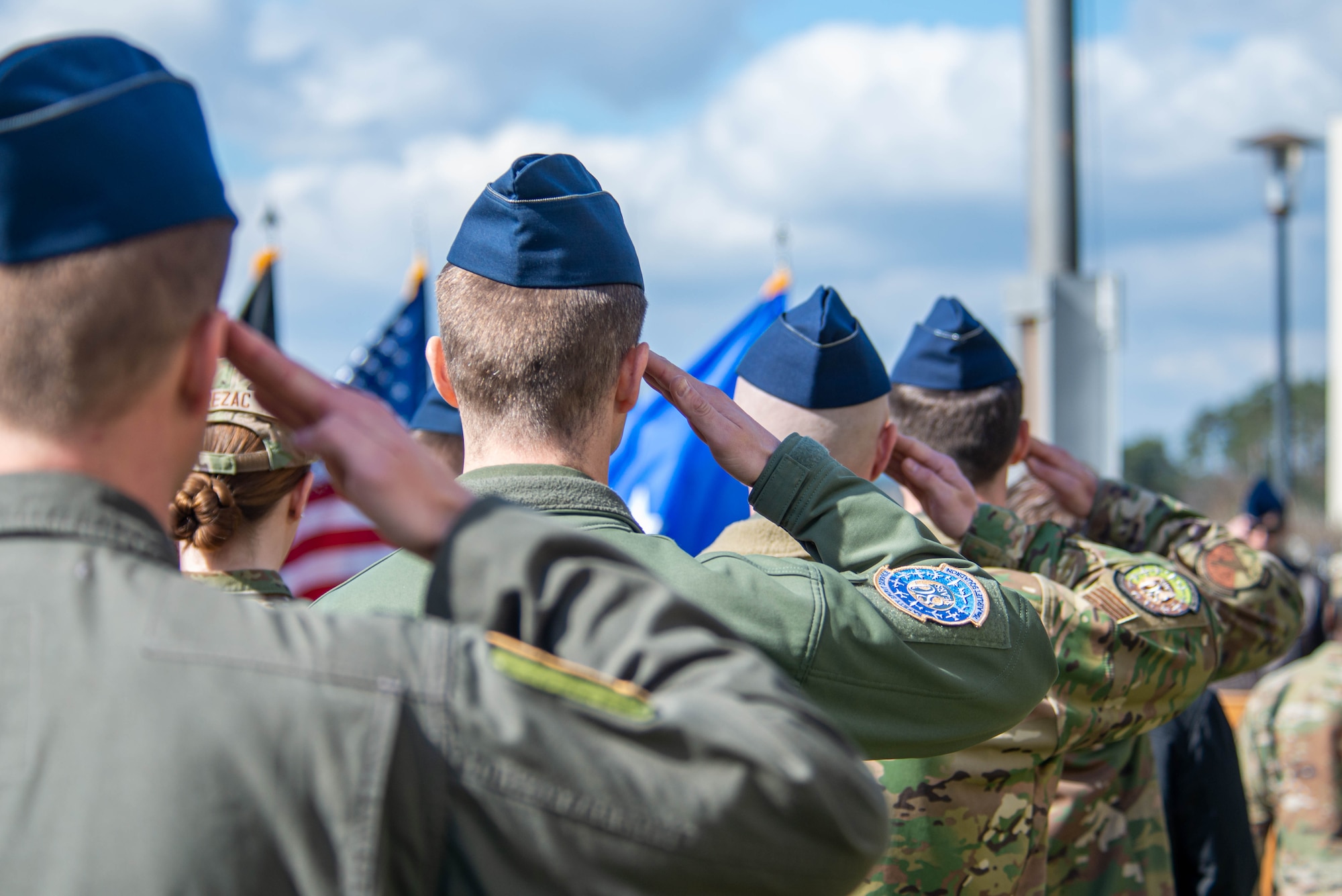 Airmen salute during the playing of taps
