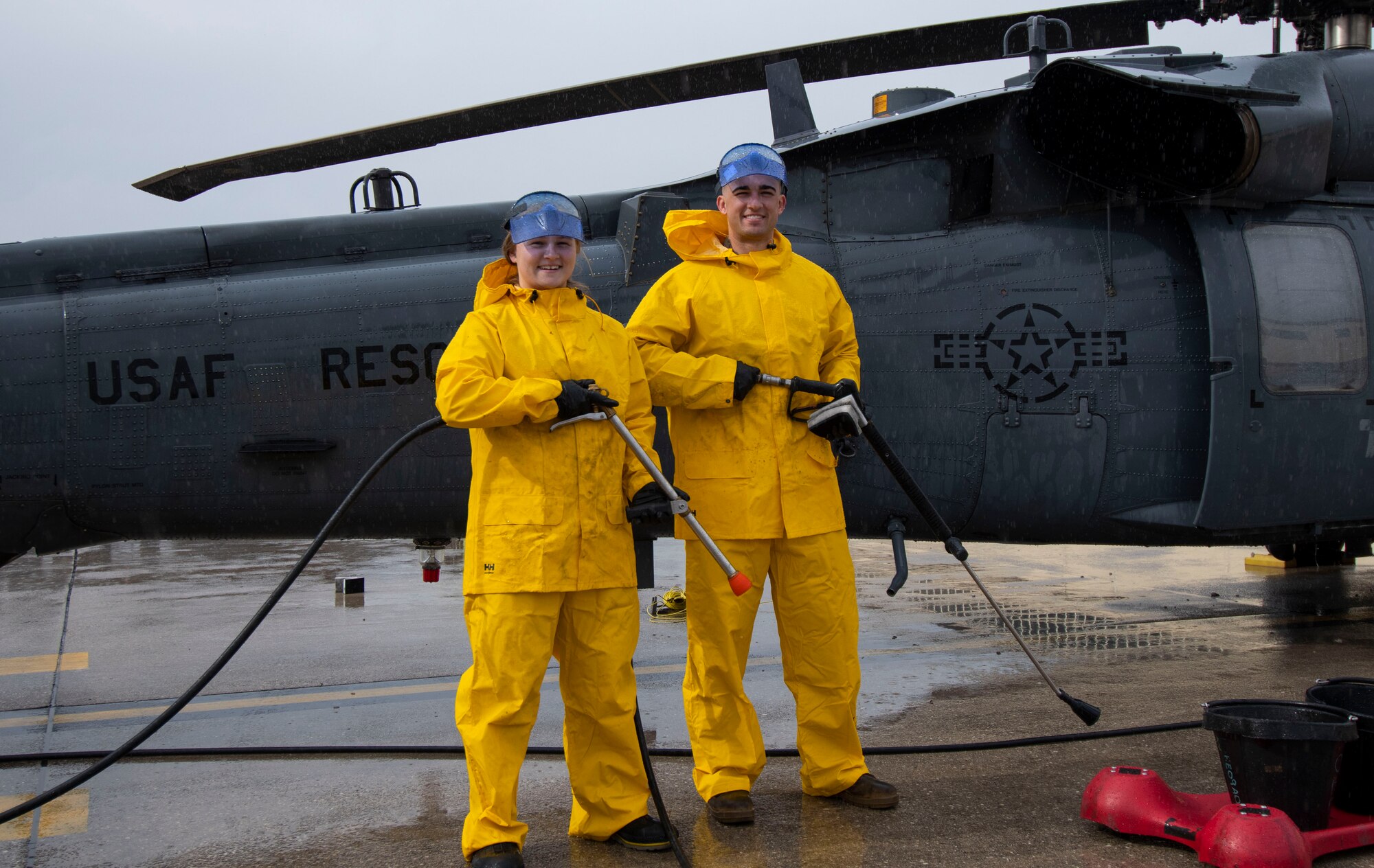 U.S. Air Force 2nd Lt. Constance Stormzand, 555th Fighter Generation Squadron sortie support flight commander, left, and 2nd Lt. Samuel Rick, 56th Rescue Generation Squadron sortie support flight commander, right, pose for a photo in front of an HH-60G Pave Hawk helicopter as part of an immersion tour