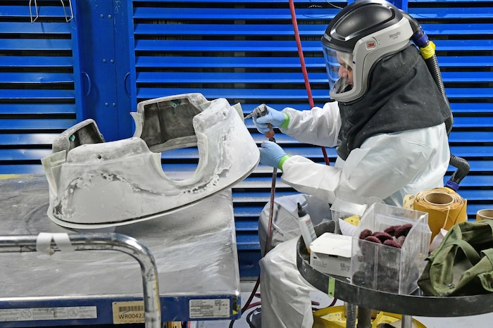 Man sanding aircraft part