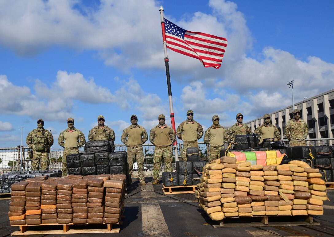 Members of U.S. Coast Guard Law Enforcement Detachment 406 pose for a photo with $69 million in illegal narcotics aboard USS Farragut (DDG 99) in Port Everglades, Florida, April 4, 2023.