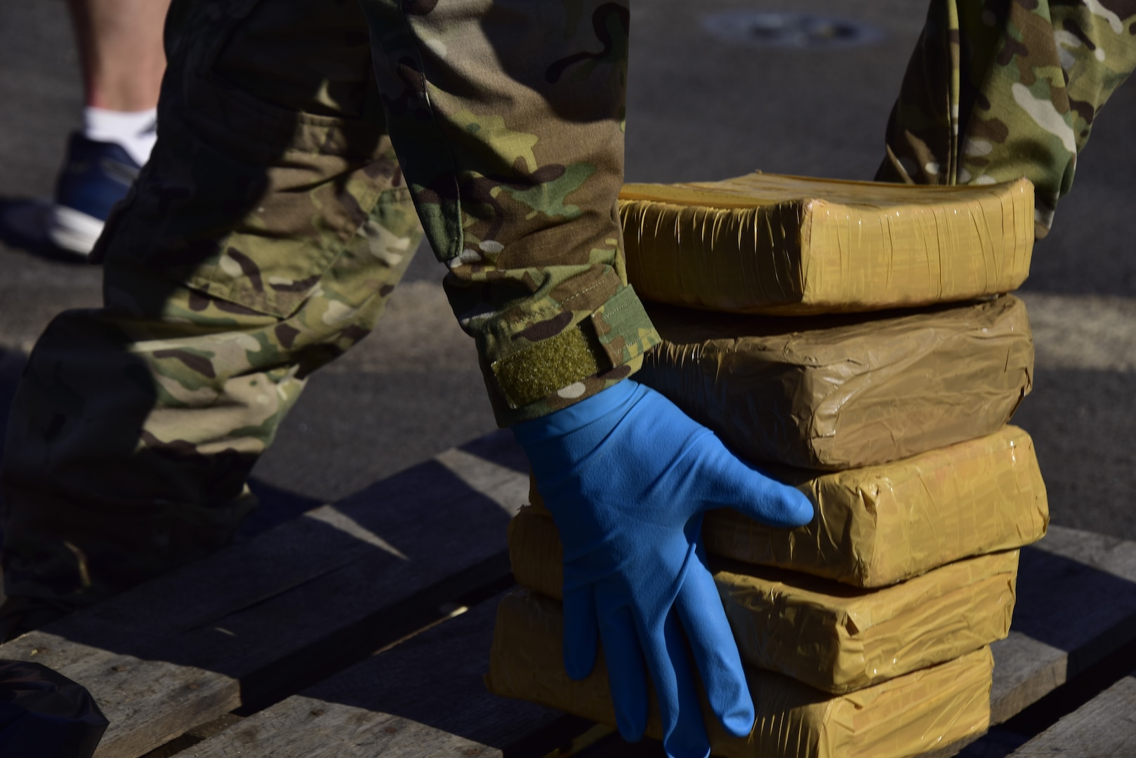 A member of U.S. Coast Guard Law Enforcement Detachment 406 offloads interdicted narcotics aboard USS Farragut (DDG 99) in Port Everglades, Florida, April 4, 2023.