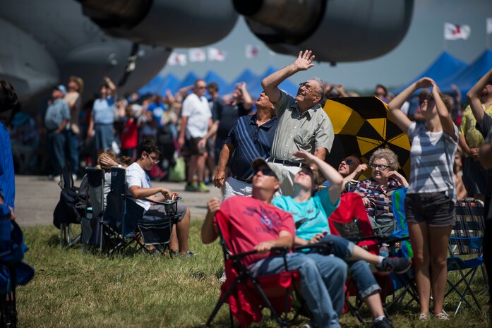 group of people staring up at airplanes