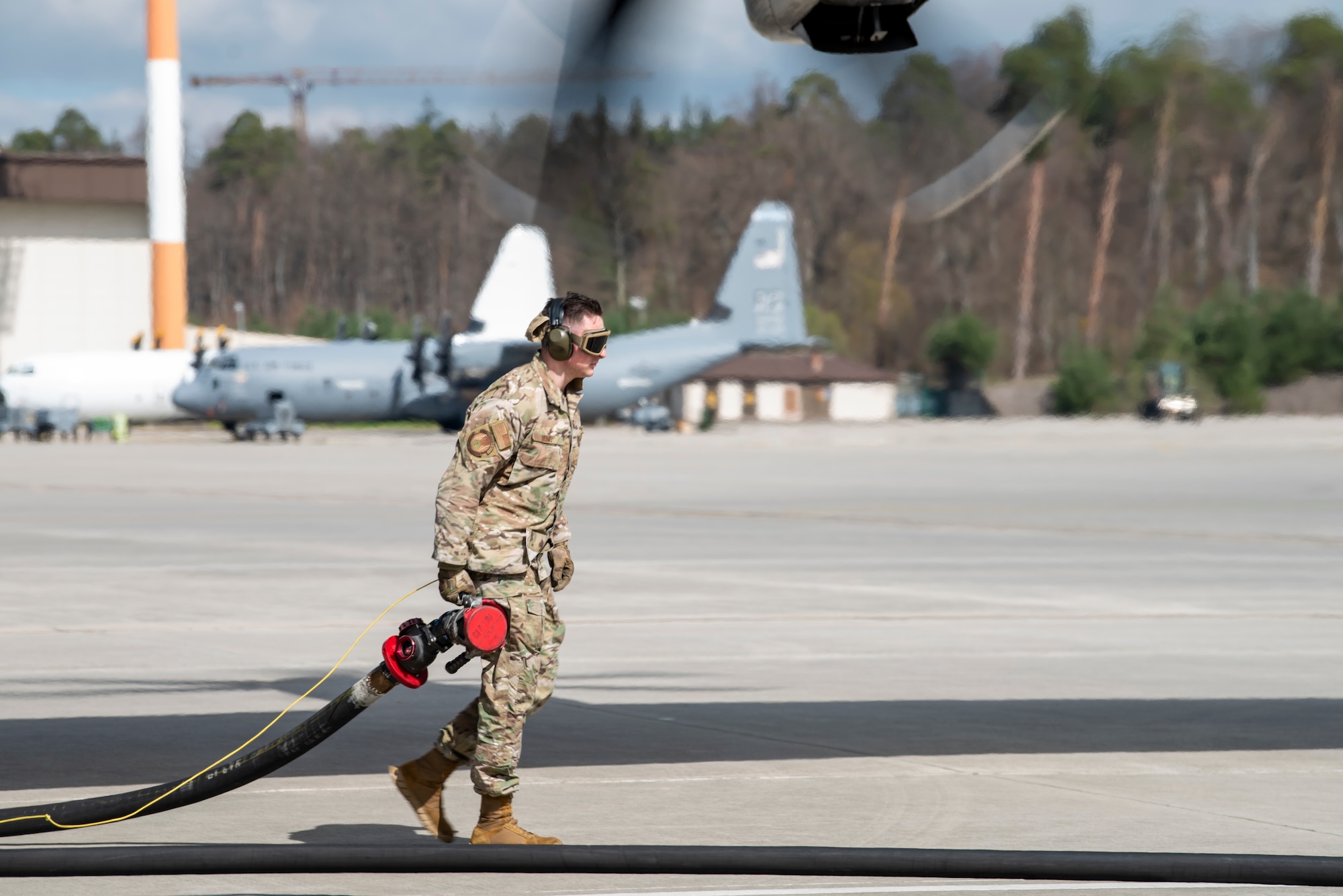 Airman carries fuel hose
