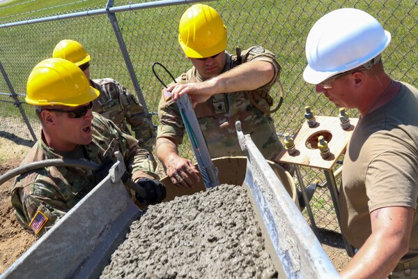 Engineers with 601st Engineer Detachment, pour concrete into the base of what will be one of 28 light poles at the Central Receiving Shipping Point at Fort McCoy, Wis., June 23, 2022. Huntsville Center’s Energy Savings Performance Contracts program utilized by Fort McCoy includes lighting upgrades and improvements throughout the expansive Army Reserve installation.