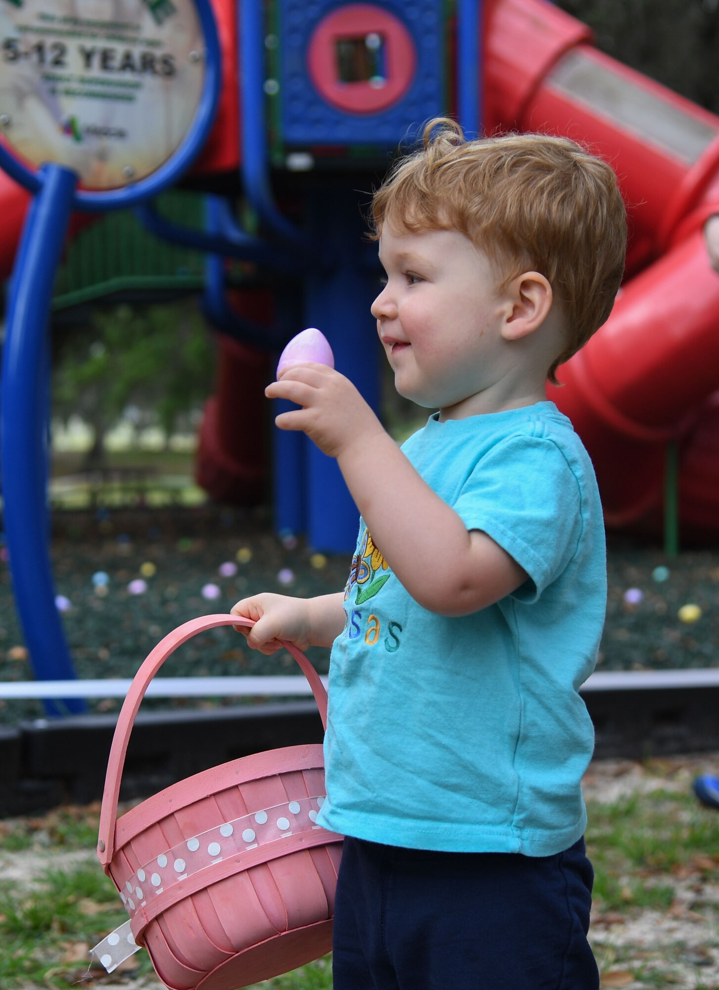 Max Schaaf, son of U.S. Air Force Maj. Andrea Schaaf, 81st Communications Squadron commander, holds up an Easter egg during Easter in the Park at Keesler Air Force Base, Mississippi, April 1, 2023.