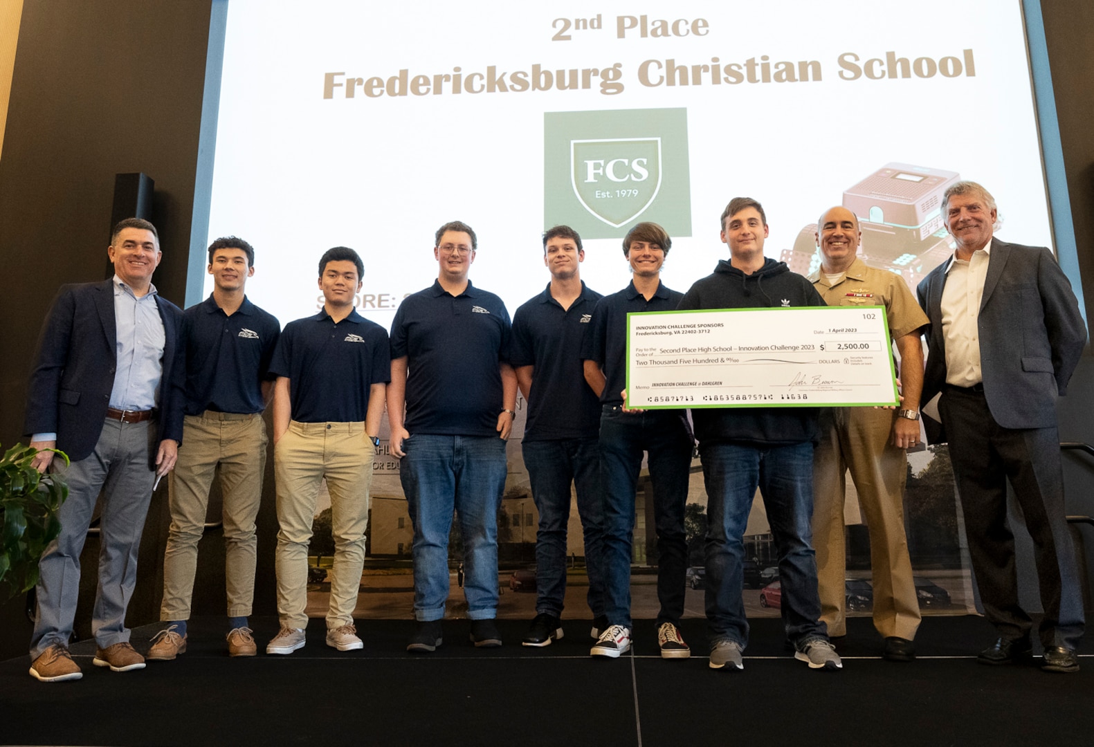 IMAGE: Naval Surface Warfare Center Dahlgren Division’s Technical Director Dale Sisson Jr., SES, and Commanding Officer Capt. Philip Mlynarski along with University of Mary Washington’s Dr. John Burrow (left) pose with the Fredericksburg Christian School (FCS) robotics team. The FCS team placed second in this year’s High School Innovation Challenge @ Dahlgren competition.