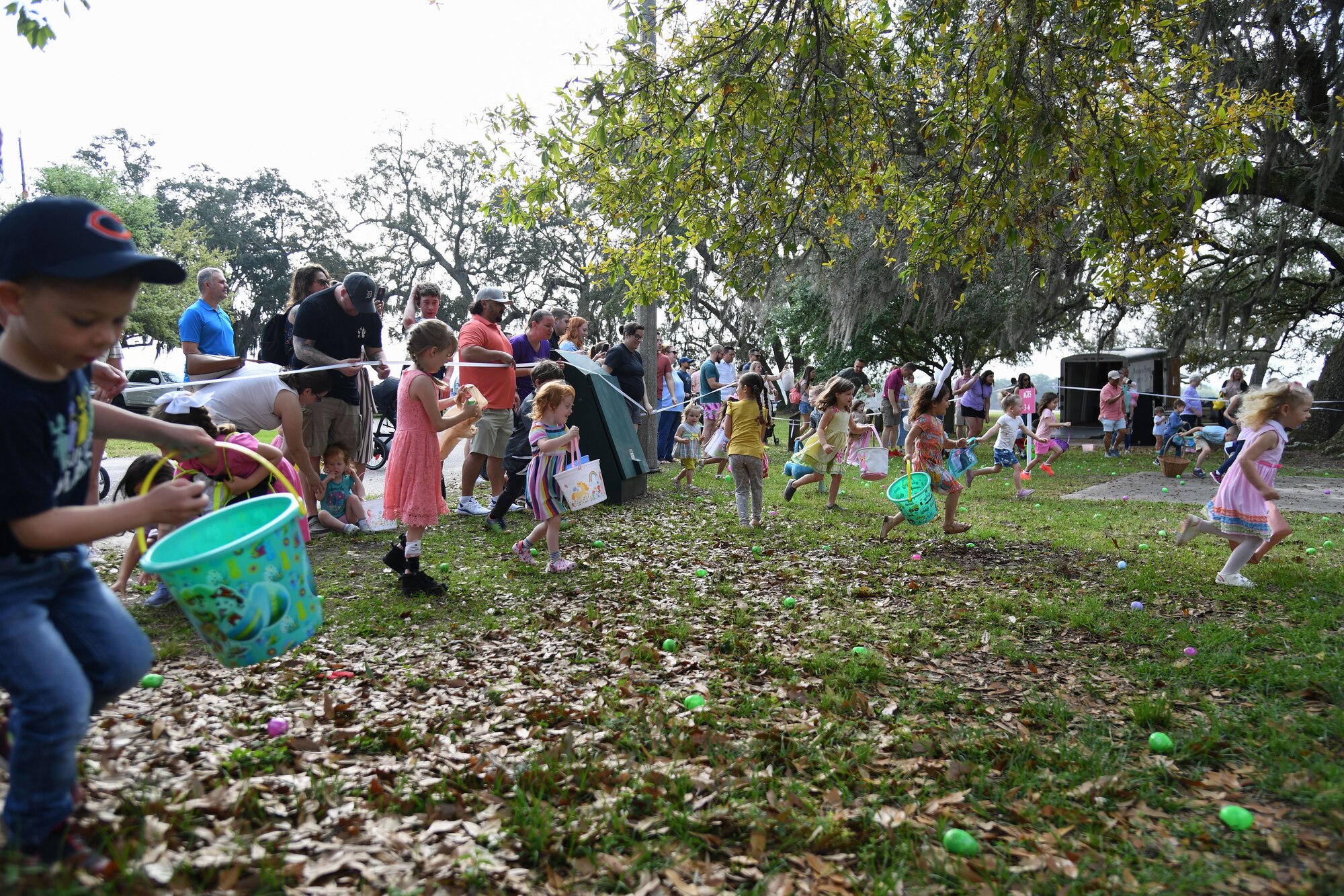 Children of Keesler personnel pick up Easter eggs during Easter in the Park at Keesler Air Force Base, Mississippi, April 1, 2023.