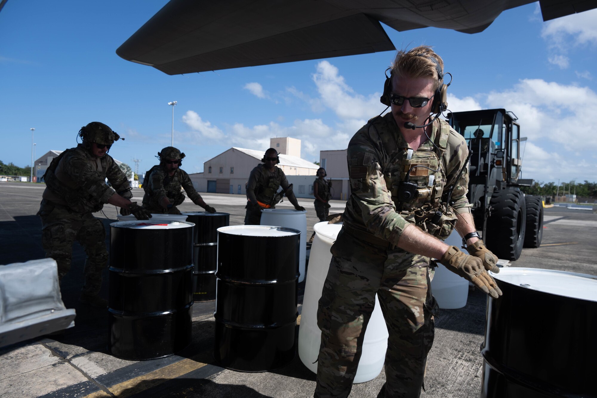 Airmen transfer cargo from forklift to C-130J on the flight line.