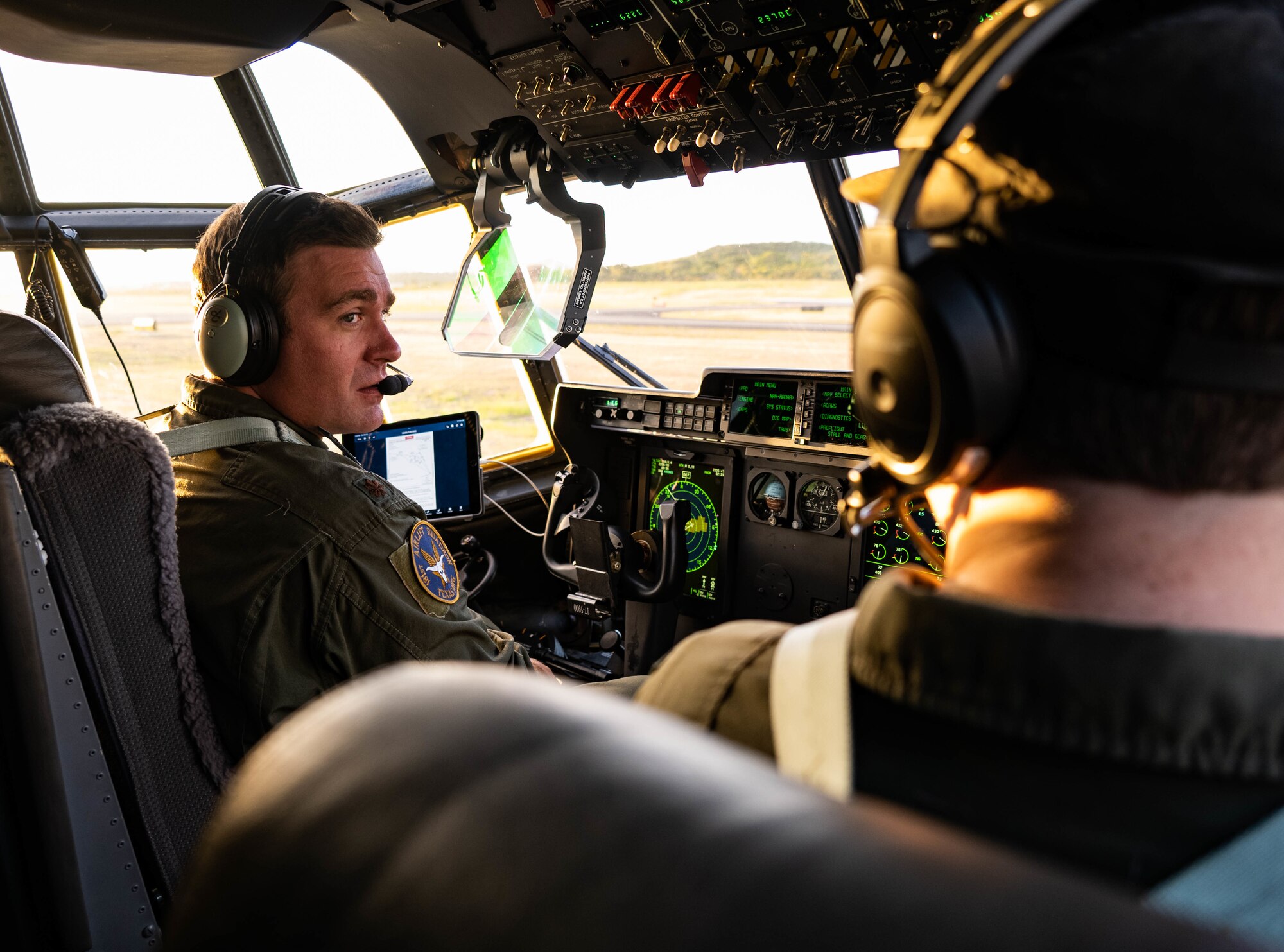 Pilot talks to co-pilot in flight deck of C-130J.