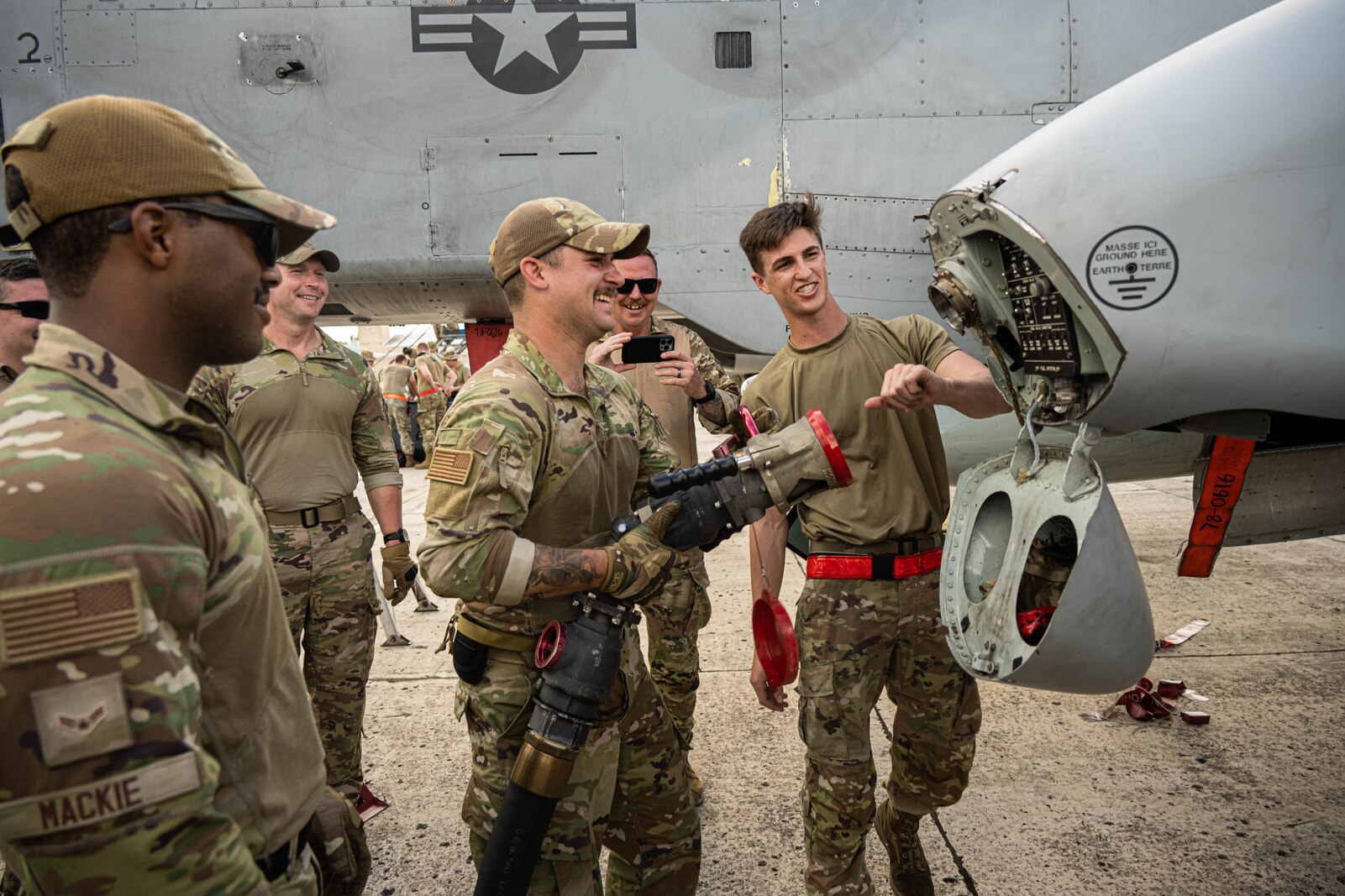 Airman explains A-10 refueling to others on flight line.
