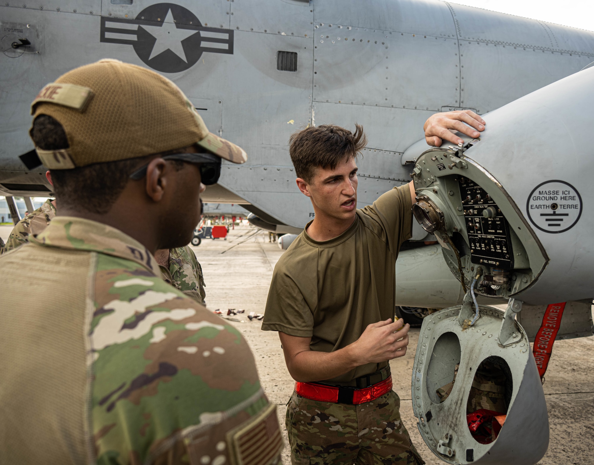 Airman explains refueling an A-10 to others on the flight line.