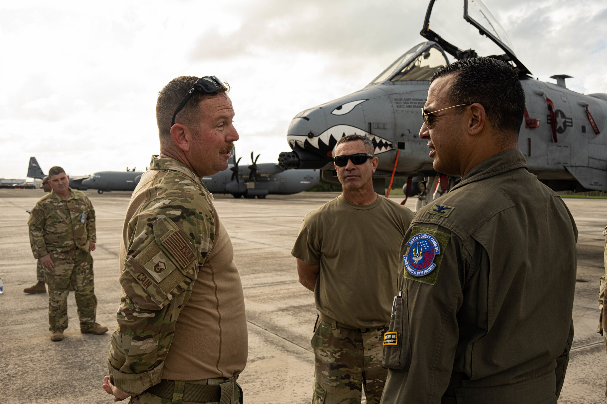 Airmen talk in front of an A-10 on flightline.