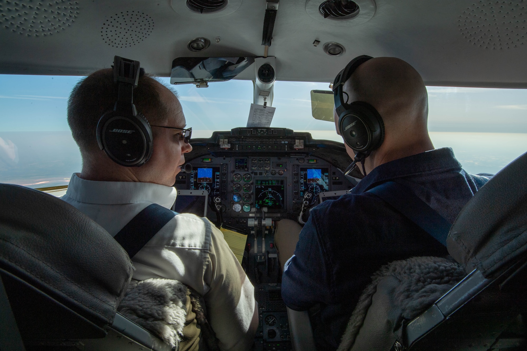 Maj. Kirk Schlueter, 76th Airlift Squadron aircraft commander, left, and Maj. Tyler Neidecker, 76th AS co-pilot, fly a C-21 Learjet from Ramstein Air Base, Germany, to Vilnius International Airport, Lithuania, April 6, 2023.