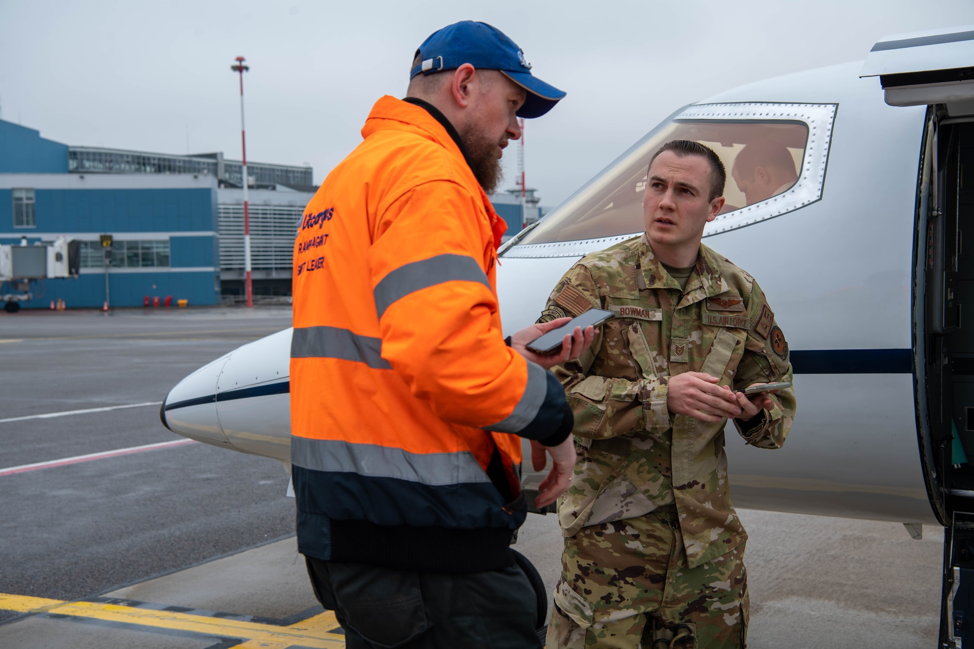 A member of the ground handling crew greets Tech. Sgt. Brendon Bowman, 86th Aeromedical Evacuation Squadron flight examiner and emergency medical paramedic, at Vilnius International Airport, Lithuania, April 6, 2023.