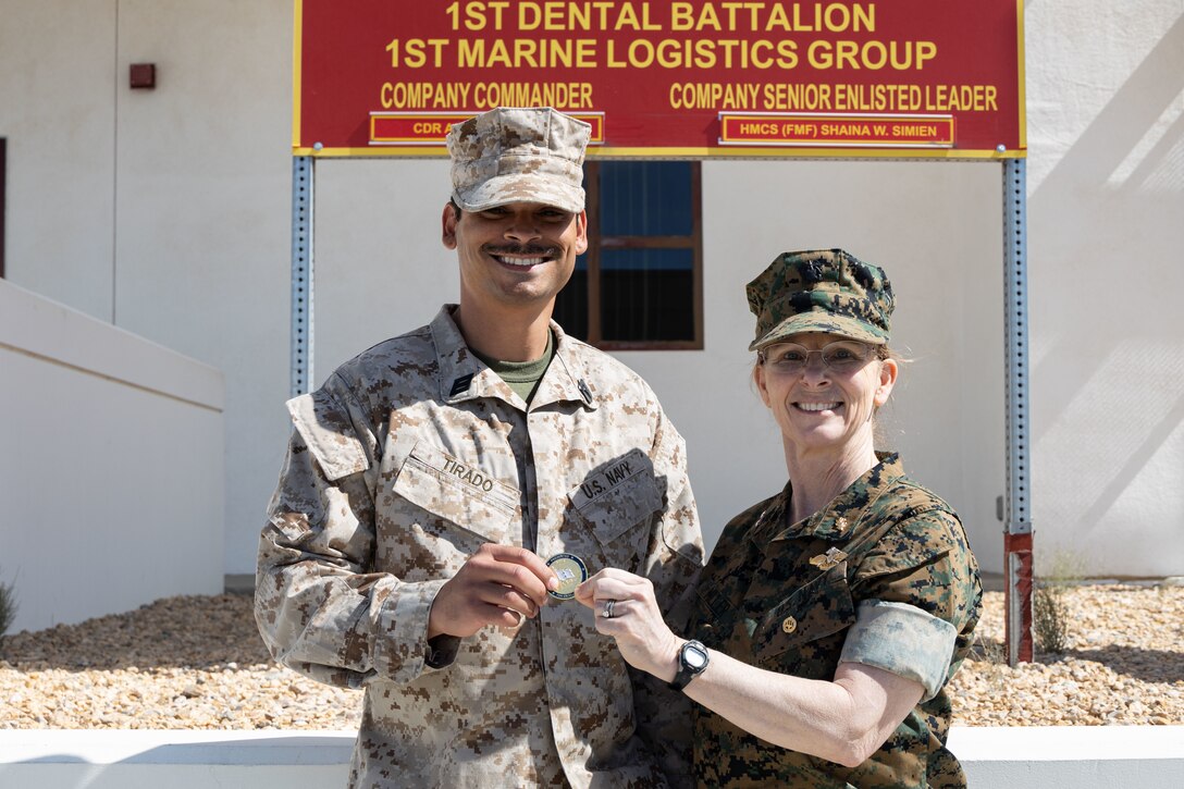U.S. Navy Rear Adm. Pamela Miller, medical officer of the Marine Corps, presents a challenge coin to a Sailor assigned to 23rd Dental Company during an installation visit at Marine Corps Air Ground Combat Center, Twentynine Palms, California, March 13, 2023. Miller is responsible for working directly with Headquarters Marine Corps and the Commandant of the Marine Corps to ensure appropriate medical care is provided to service members and their families. (U.S. Marine Corps photo by Cpl. Makayla Elizalde)