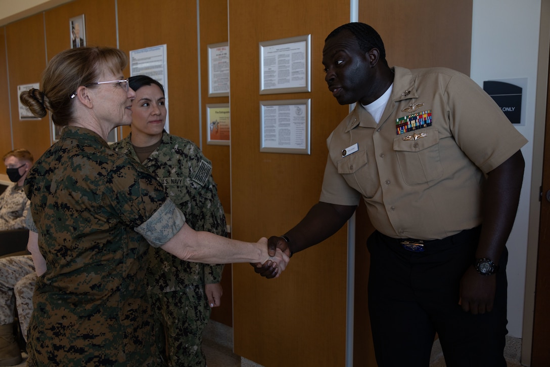 U.S. Navy Rear Adm. Pamela Miller, medical officer of the Marine Corps, gives a coin to a Sailor during an installation visit at Marine Corps Air Ground Combat Center, Twentynine Palms, California, March 13, 2023. Miller is responsible for working directly with Headquarters Marine Corps and the Commandant of the Marine Corps to ensure appropriate medical care is provided to service members and their families. (U.S. Marine Corps photo by Cpl. Makayla Elizalde)