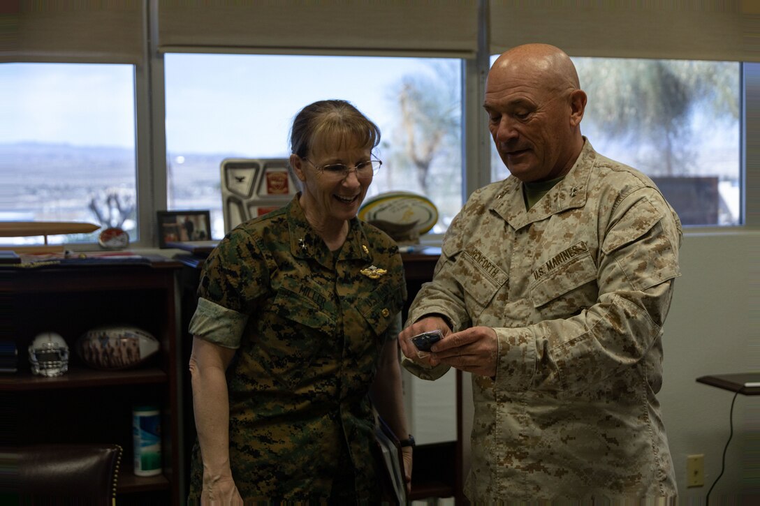 U.S. Marine Corps Maj. Gen. Austin Renforth, commanding general, Marine Corps Air Ground Combat Center (MCAGCC), presents U.S. Navy Rear Adm. Pamela Miller, medical officer of the Marine Corps, with a challenge coin at MCAGCC, Twentynine Palms, California, March 13, 2023. Miller is responsible for working directly with Headquarters Marine Corps and the Commandant of the Marine Corps to ensure appropriate medical care is provided to service members and their families. (U.S. Marine Corps photo by Cpl. Makayla Elizalde)