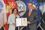 man and woman in suits in front of service flags