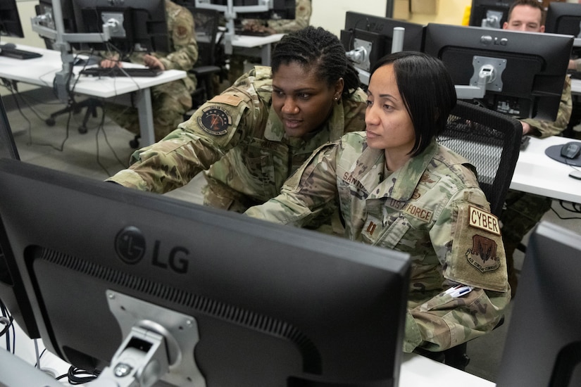 Troops work on laptops.