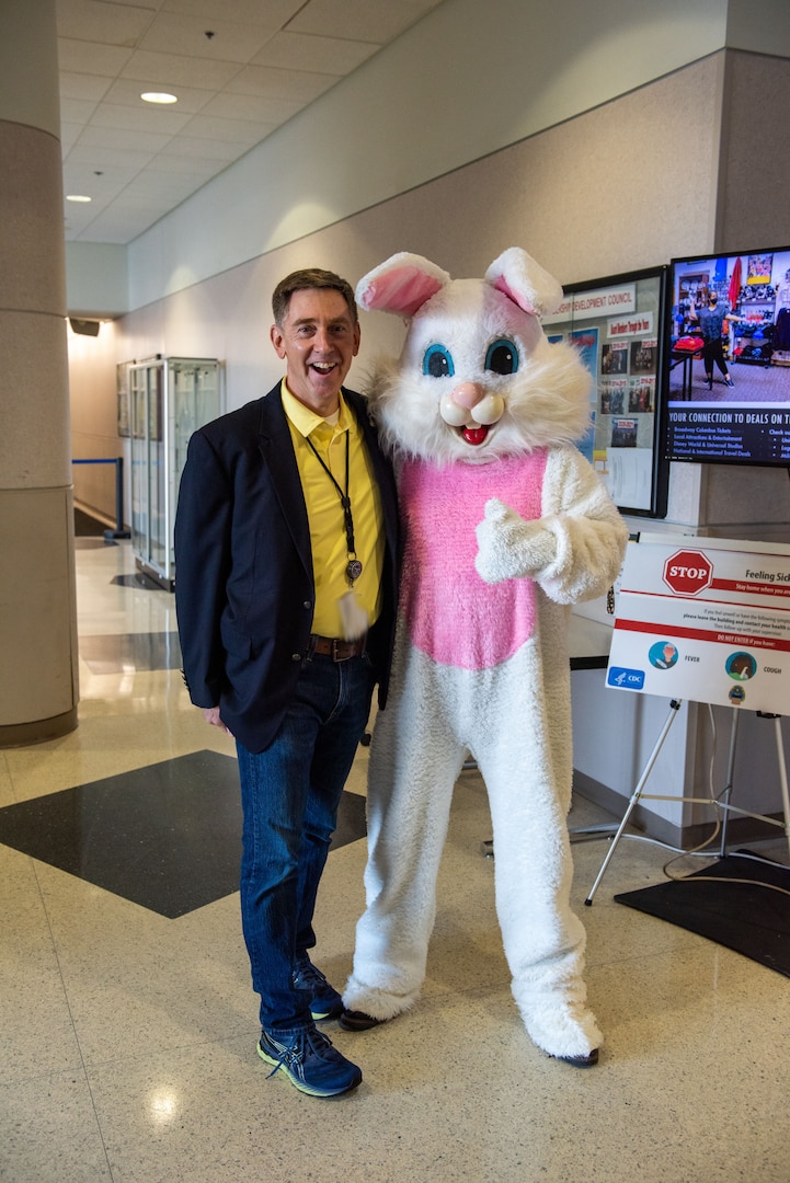 A man and a person dressed as the Easter Bunny pose for a photo.
