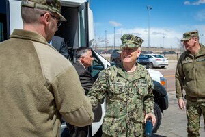 Man in uniform shakes hands with another man in uniform