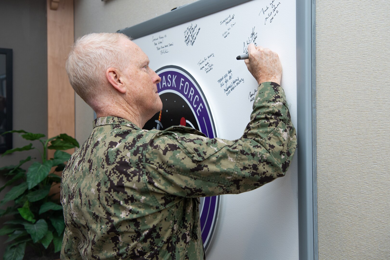 Man in uniform signs a board