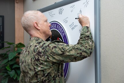 Man in uniform signs a board