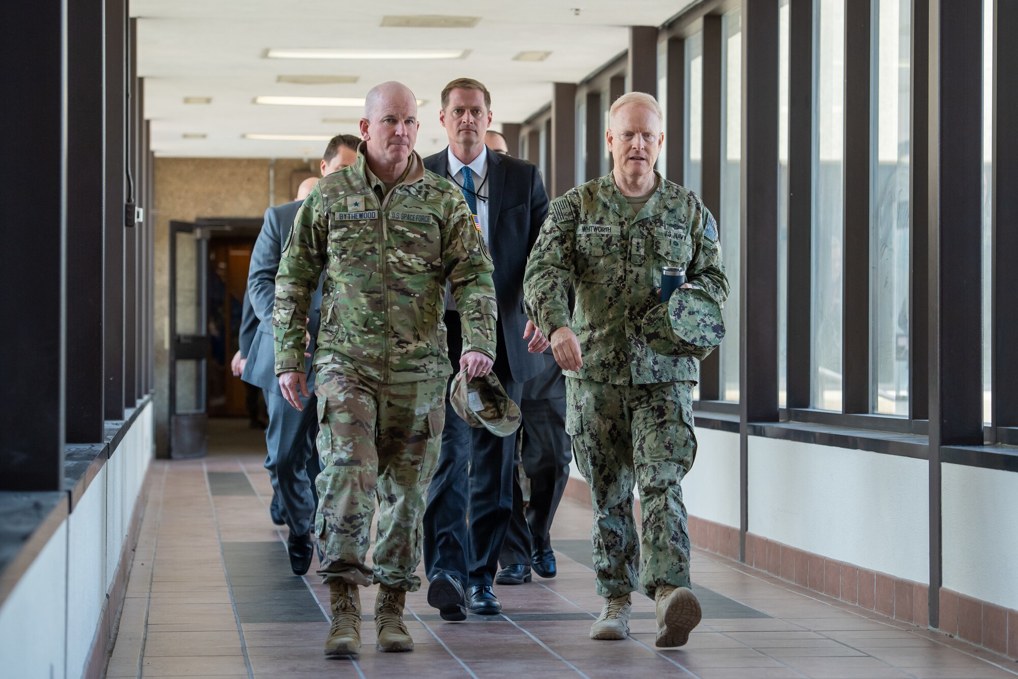 Two men in uniform walking down a hallway