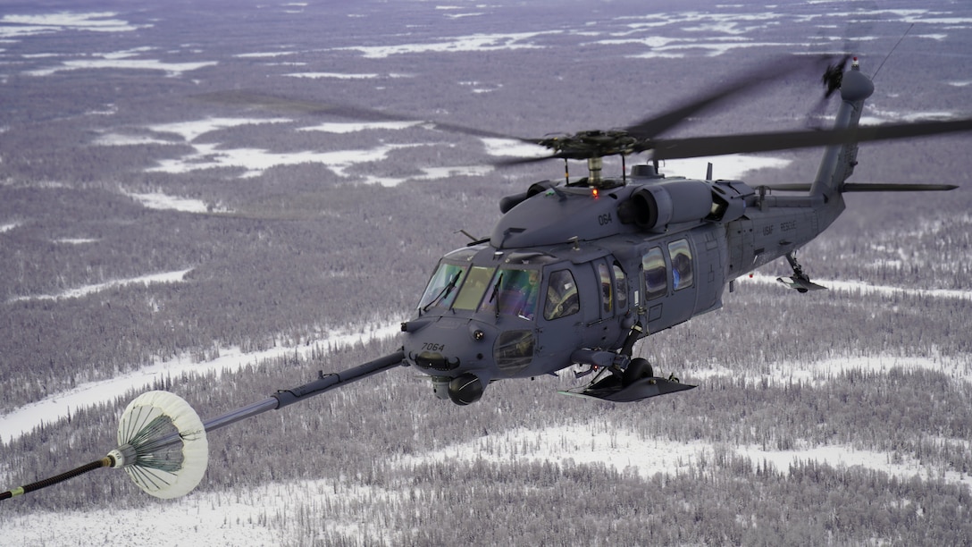 Alaska Air National Guardsmen with the 210th Rescue Squadron fly an HH-60G Pave Hawk helicopter during an air-to-air refuel from a 211th RQS HC-130J Combat King II aircraft over the Lower Susitna Valley near Anchorage, Alaska, Feb. 7, 2023. Both aircraft along with rescue personnel from the 212th RQS sit alert for the federal search and rescue mission across Alaska’s vast Arctic region. The HC-130J’s aerial refueling capability significantly extends the HH-60G Pave Hawk’s range for conducting search and recovery missions.