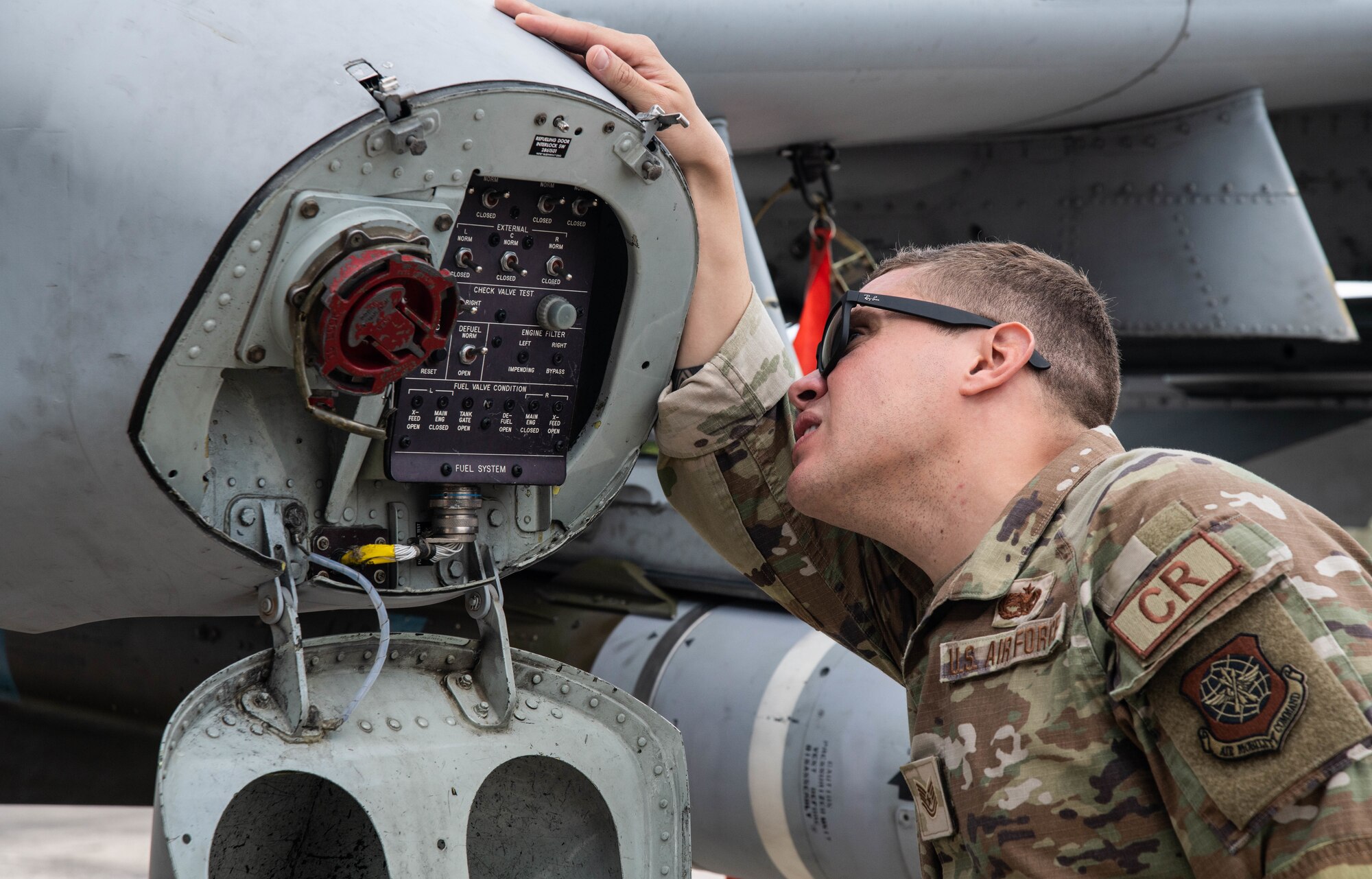 Airman looks into A-10 refueling port.