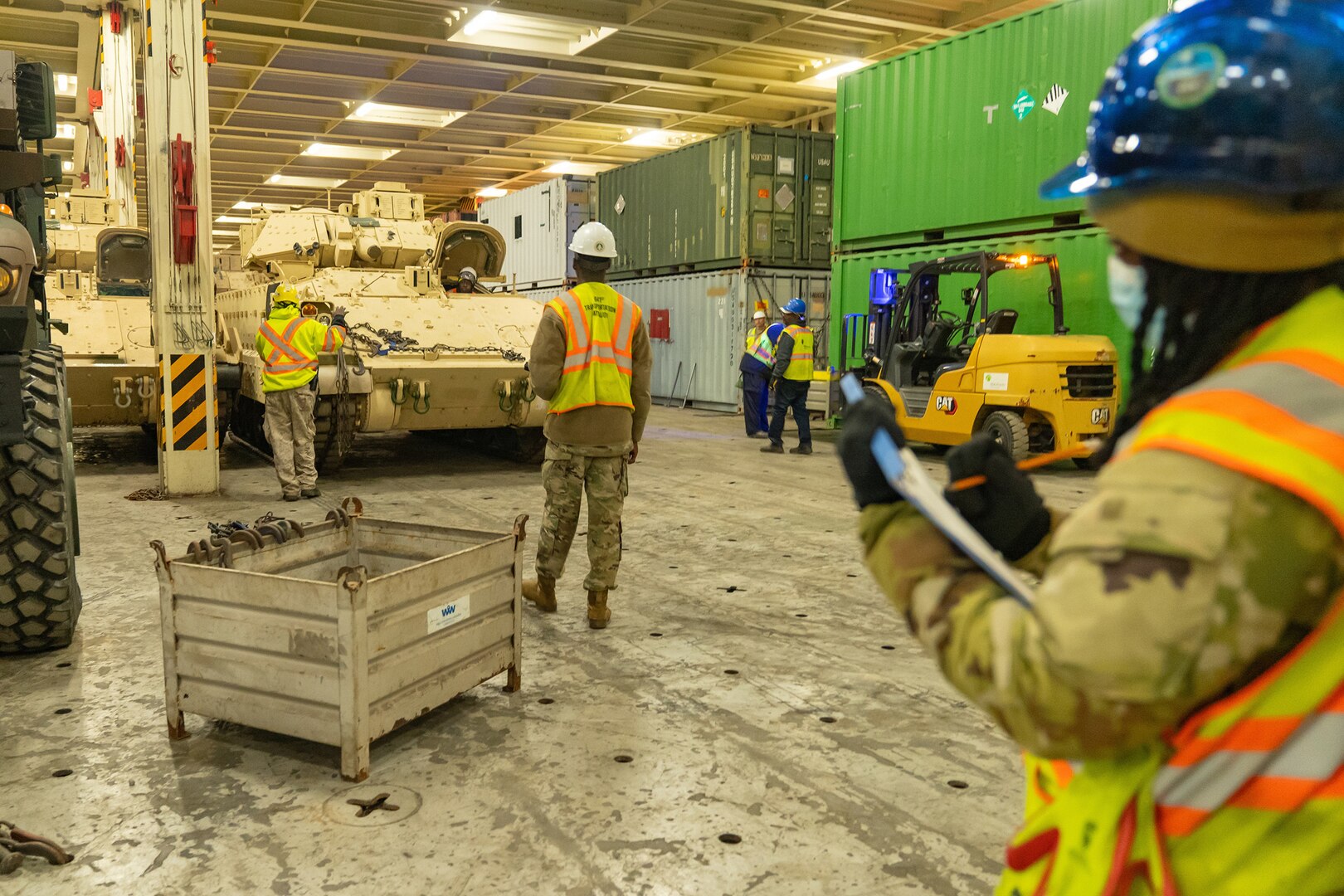 Soldiers work in a warehouse.