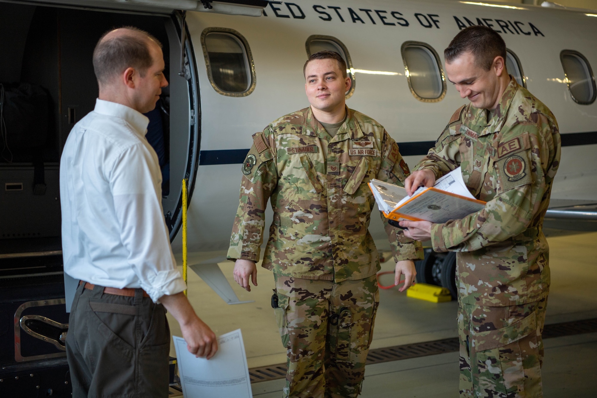 Tech. Sgt. Alexander Stinauer, 86th Aeromedical Evacuation Squadron aeromedical evacuation technician, middle, and Tech. Sgt. Brendon Bowman, 86th AES flight examiner and emergency medical paramedic, right, greets the Maj. Kirk Schlueter, 76th Airlift Squadron aircraft commander, left, at Ramstein Air Base, April 6, 2023.