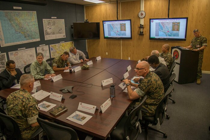 U.S. Marine Corps Lt. Col. Alexander H. Miller, senior watch officer, Marine Corps Installations West, Marine Corps Base, Camp Pendleton, far right, gives the 'Commander's Update Brief' to U.S. Marine Corps Brig. Gen. Kevin J. Killea, commanding general, MCIWEST-MCB, Camp Pendleton, during exercise Semper Durus 17 on Camp Pendleton, Calif., April 13, 2017. Semper Durus is a regional command post exercise and is comprised of a series of field training scenarios designed to improve regional command and control, enhance interagency coordination, and improve installation capabilities to respond to, and recover from, a crisis event and validate the installation mission assurance all-hazard plan.