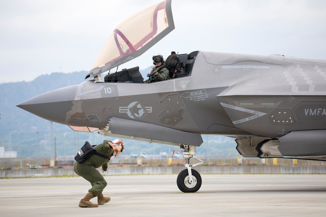 U.S. Marine Corps Lance Cpl. Herbert Tunley III, a fixed wing aircraft mechanic, signals to Maj. Douglas Kansier, F-35B Lightning II aircraft pilot and executive officer of Marine Fighter Attack Squadron 242 at Marine Corps Air Station Iwakuni, Japan, April 5, 2023. Marines with Marine Aircraft Group 12 routinely conduct arming, expeditionary refueling and flight operations to maintain proficiency and readiness in support of a free and open Indo-Pacific.