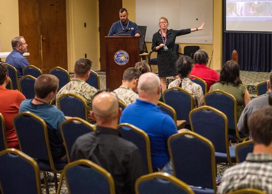 (center) DeAnna Pedersen, Naval Surface Warfare Center Panama City Division (NSWC PCD) Purchasing Branch head, briefs NSWC PCD Science and Technology Department (X Dept.) personnel about a new purchasing program onboard Naval Surface Activity Panama City, Fla., March 28. This pilot program, the Grainger Fourth Party Logistics Program, presents a new option for purchasing materials and the effort was a collaboration between the purchasing branch and X Dept. (U.S. Navy photo by Eddie Green)
